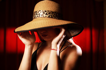 Portrait of a beautiful woman with red lips in hat isolated at red curtain with copy space.Headshot with different emotions.