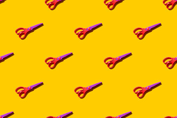 Seamless pattern of figure scissors on orange background. Top view. Hard light.