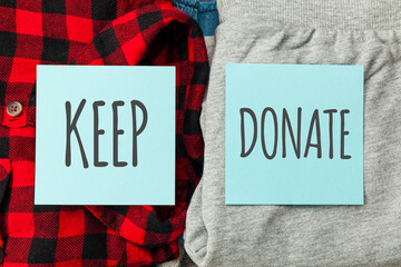 Stack of old clothes to discard (declutter) or keep. Recycle clothes, eco cotton.