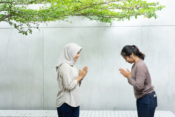 two friend with greeting gestures apologize when they meet outside