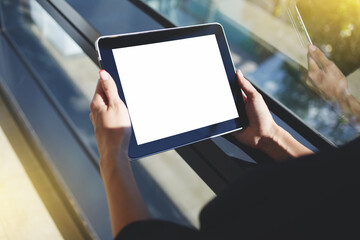 Beautiful smiling woman looking at camera while sitting with touch pad 