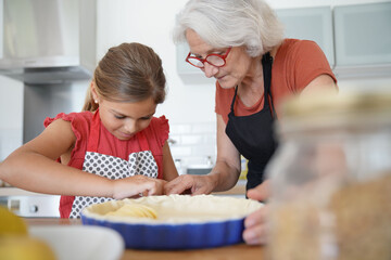 Grandmother with grandkid making apple pie