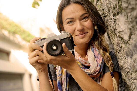 Close up of young woman taking a photo with a vintage camera