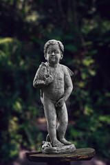 Fototapeta na wymiar statue of a Menneken Pis in a garden include clipping path
