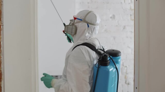Man in hazmat making disinfection in flat. Coronavirus disinfection.