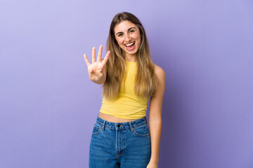 Young woman over isolated purple background happy and counting four with fingers