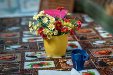 DIY concept. Ceramic handmade decorative glazed dish with flowers and tea on the table..