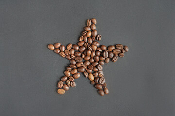 Fresh coffee beans on the grey table background. Star shape. 