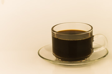 Closeup of black coffee in a clear glass container The image has blank space beside the object and has a white background. The image is partially clear.