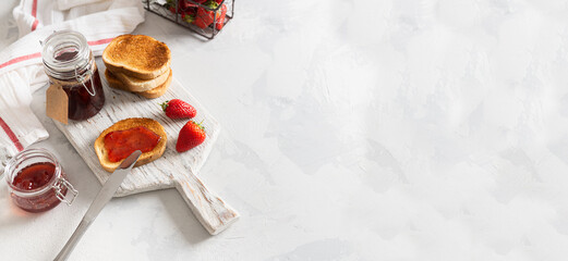 Obraz na płótnie Canvas Healthy breakfast with natural organic strawberry jam or marmalade and toasts on white background. Side view, copy space. Bakery, cafe banner. Strawberry confiture
