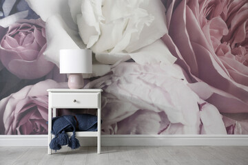 White nightstand near wall with floral wallpaper, space for text. Stylish room interior