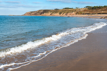 Warm afternoon on empty beach with dunes in Brittany, France.