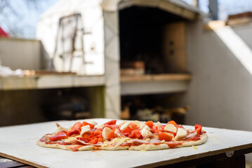 Making of homemade Italian pizza in fireplace brick oven.