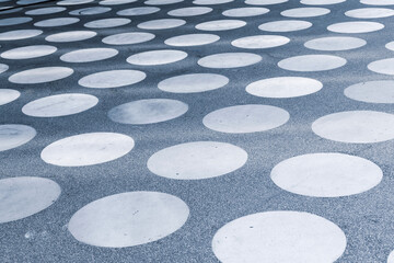 A concrete square with a symmetrical white circle pattern seen in perspective.