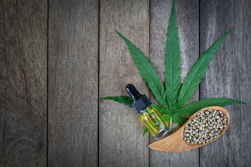 CBD oil cannabis extract, Hemp oil bottles and Cannabis seeds on a wooden table,  Medical cannabis concept, copy space.