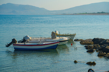 Fototapeta na wymiar Several boats near coast against backdrop of mountains