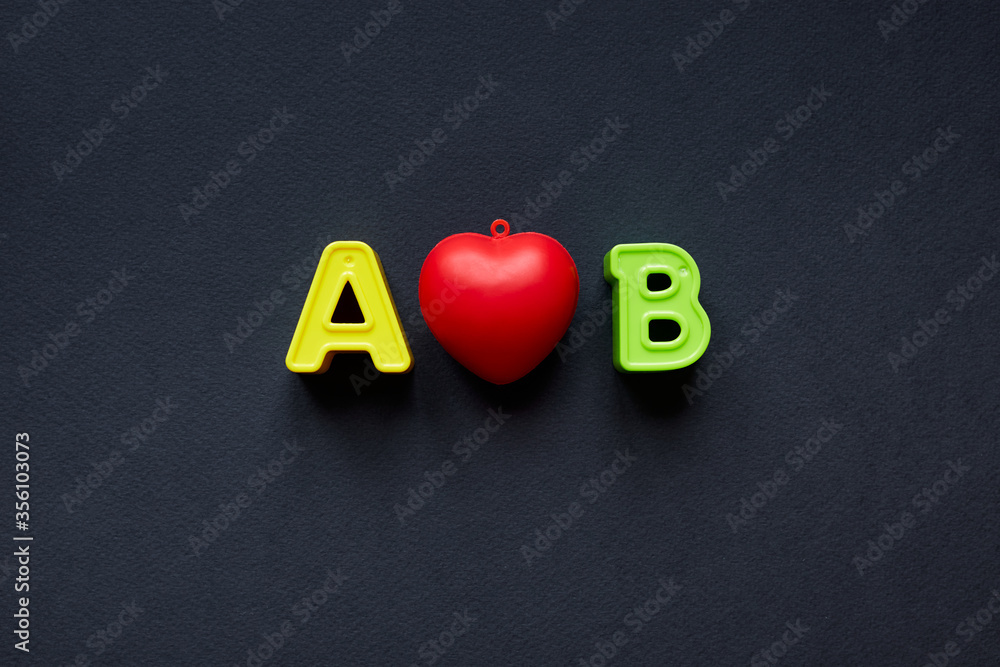 Fototapete yellow and green letters a and b uppercase with red heart in the middle. capital letters a and b iso