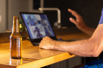 Video call with several friends from home while having a beer. Selective focus. Quarantine concept