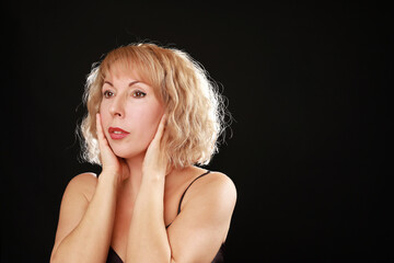 Portrait of middle-aged caucasian blonde woman isolated on black background