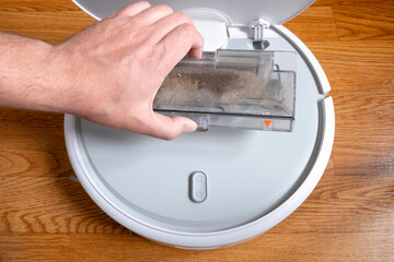 Cleaning the robot vacuum cleaner dust bin, robot vacuum cleaner maintenance service. Cleaning the trash bin of robot vacuum.