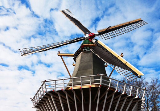 Holland. Traditional old Dutch windmill on the background of a blue sky with clouds in the spring day