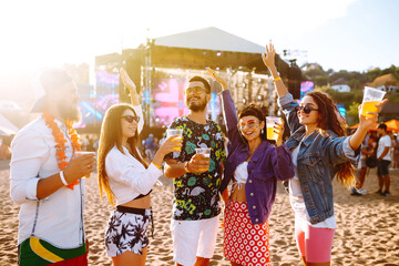 Group of friends with beer dancing and having fun at music festival together. Summer Beach party,...