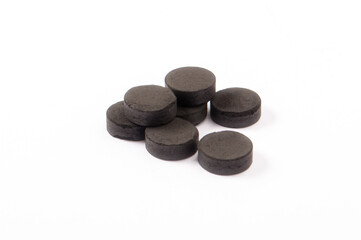 Activated carbon in tablets isolated on white. Health concept