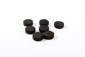 Activated carbon in tablets isolated on white. Health concept
