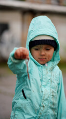Portrait of a little boy in a hood with earthworm