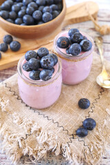 Two jars of blueberry yogurt and fresh blueberries