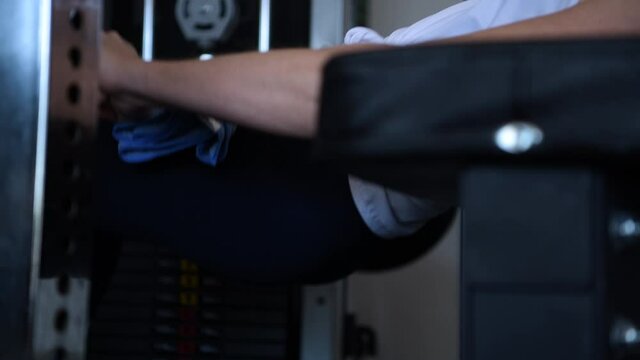 Woman performing a barbell pelvic thrust in a gym.