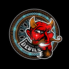 Devil's head in center of motorcycle wheel, color label on black background