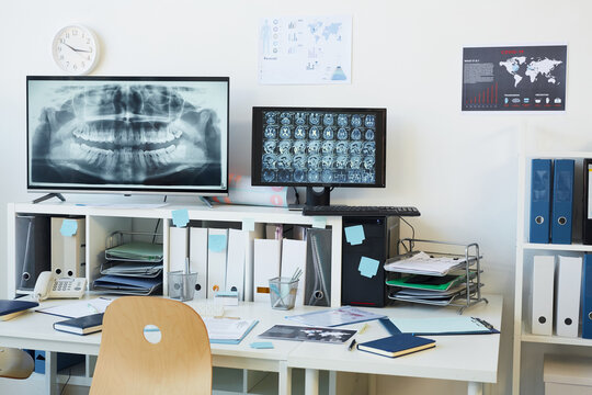 Background image of modern computer equipment in clinic, focus on digital screen with CT and X ray scans at empty workplace in clinic, copy space
