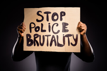 Close up photo of afro american anonymous activist man close cover face banner stop police brutality wear jumper isolated over black color background