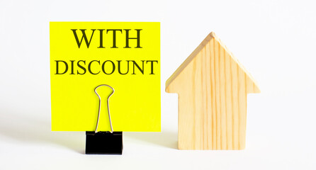 Table with wooden houses with the word WITH DISCOUNT . The concept of rental housing. Rent an apartment or house. Payment for rent.