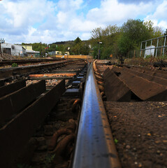 A low perspective view along a railway track. Focus is a short way along the track. Shown close to emphasise the dirt and grime along the tracks from years of continued use.