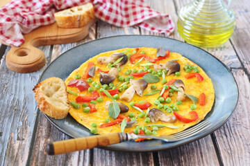 Omelet with green peas, red bell pepper and mushrooms
