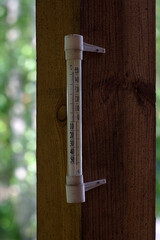 thermometer on the porch post of a wooden house