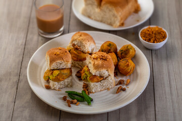vada pav with a glass of tea, very famous street food of india, specially in the state of...