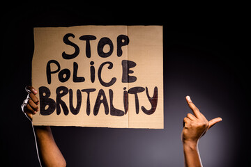 Close up photo of afro american hand hold banner stop police brutality show fuck symbol ignore haters fight rights isolated over black color background - obrazy, fototapety, plakaty