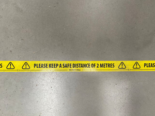 A social distancing sticker on the floor warning people to stay 2 metres apart