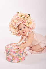 Sweet funny baby in hat with flowers. Easter greeting card, copyspace for your text. Poster for Easter holiday. Congratulations on Mother's Day. Cute baby girl. Children Protection Day