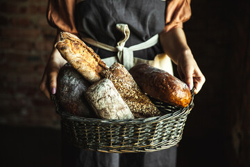 French baguettes in female hands on a black background. homemade baking