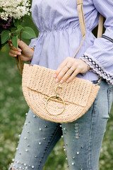 Summer bag made of raffia. Bag for the beach in the hands of the model