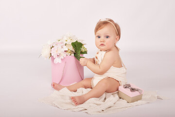 Sweet funny baby in hat with flowers. Easter greeting card, copyspace for your text. Poster for Easter holiday. Congratulations on Mother's Day. Cute baby girl. Children Protection Day.