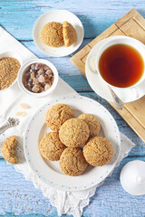 Sesame cookies and cup of tea, sweet breakfast on blue background