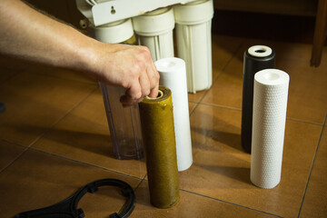 Changing filters in your home water purification system. The master prepared to replace the first...