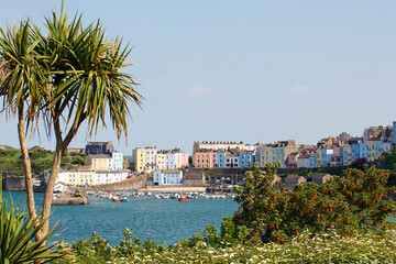 Boats moored in Tenby Harbour at high tide. The harbour is built into a corner of North Beach between the old medieval walled town and castle hill.