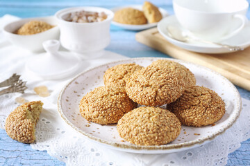 Sesame cookies and cup of tea, sweet breakfast on blue background