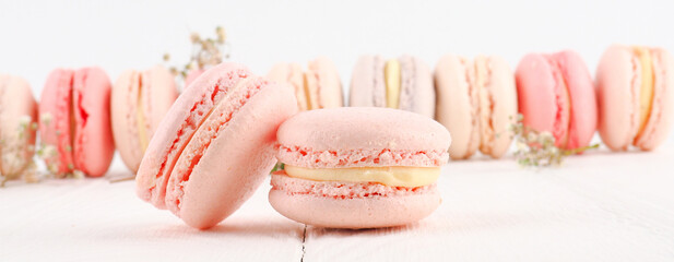 banner Colorful French or Italian macarons stack on white wood table with copy space for background. Dessert for served with afternoon tea or coffee break